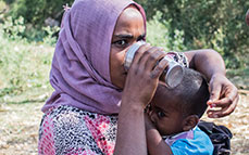 Photo of a woman and her child drinking water. Link to Gifts by Will.